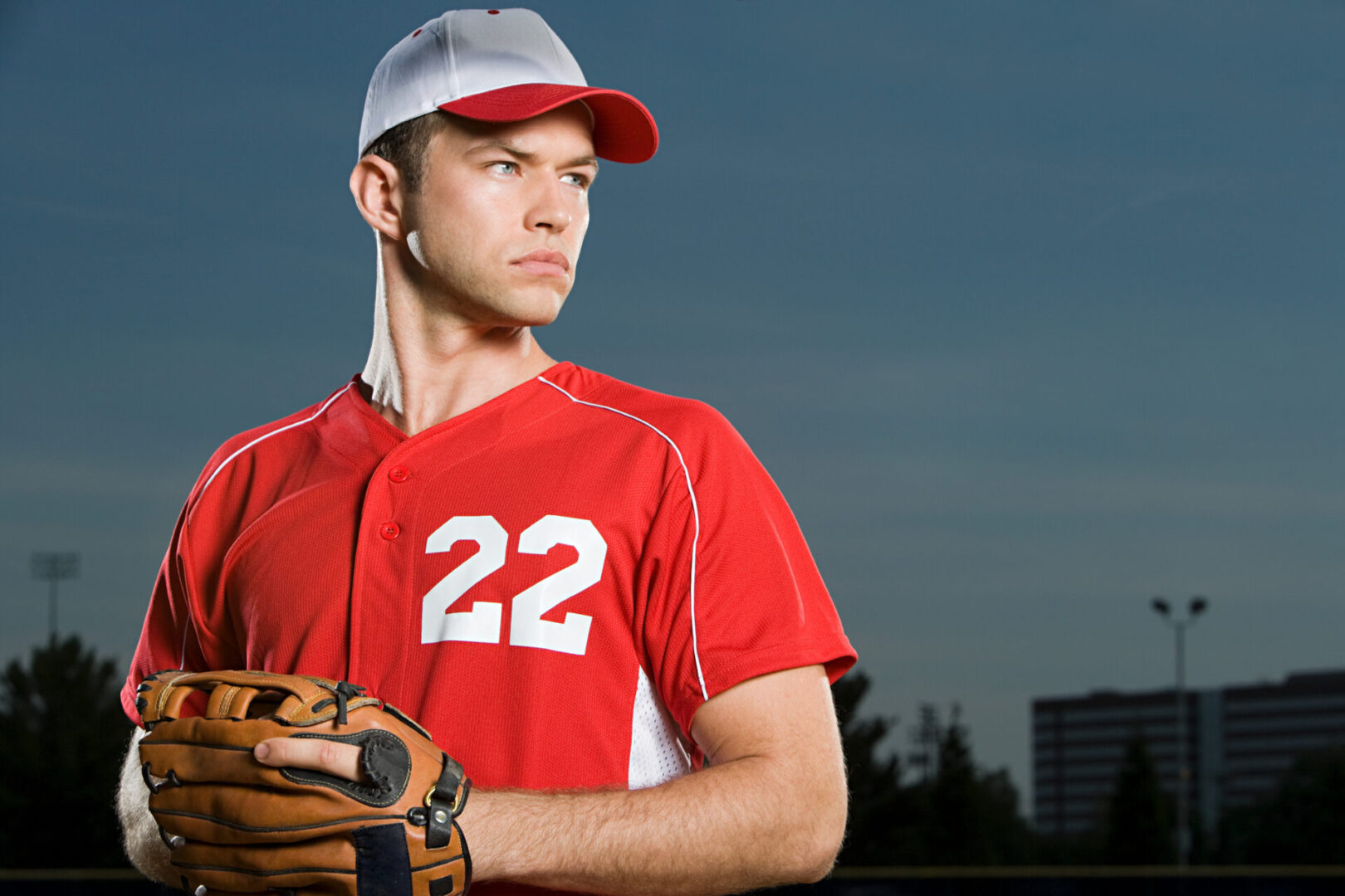 Baseball player in red jersey with number 22 holding glove.